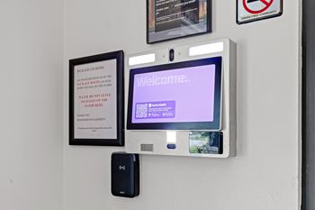 A wall-mounted monitor displays a welcome message.